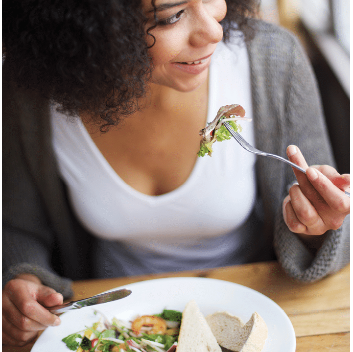 Portrait of a smiling african american woman eating in restaurant