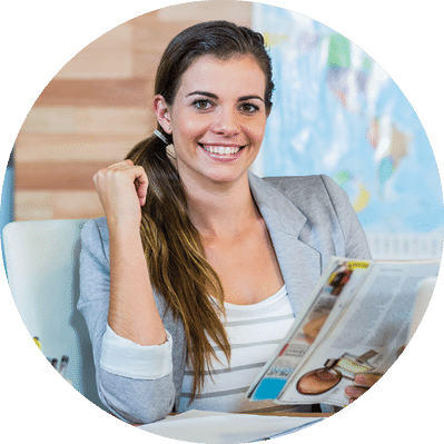 Pretty travel agent reading magazine in the office