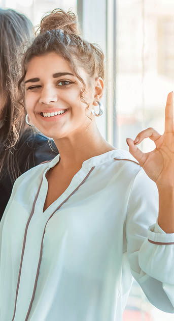 Young pretty business girls show a good gesture  Dressed in classic clothes, smiling copy space