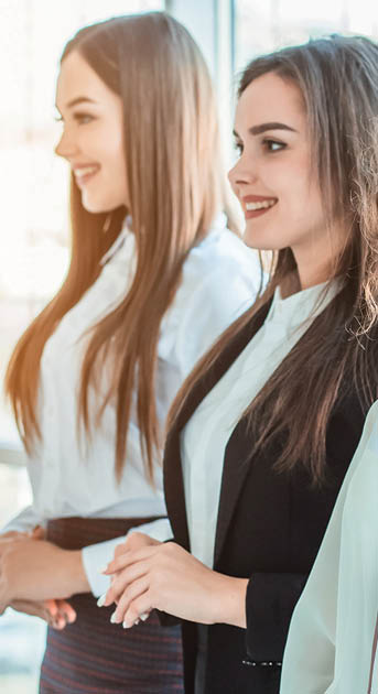 Young pretty business girls show a good gesture  Dressed in classic clothes, smiling copy space
