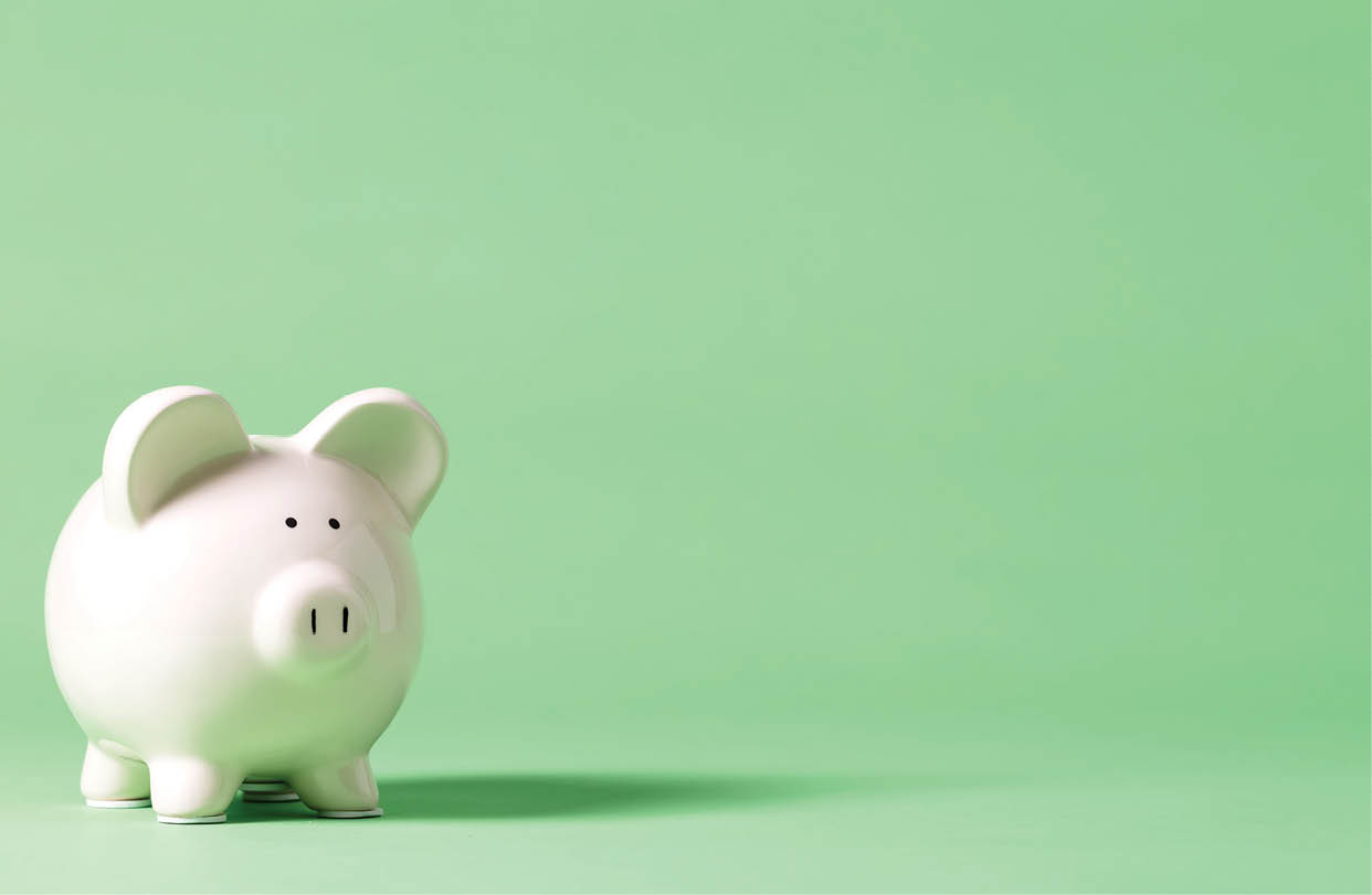 White piggy bank with glasses on a muted green background