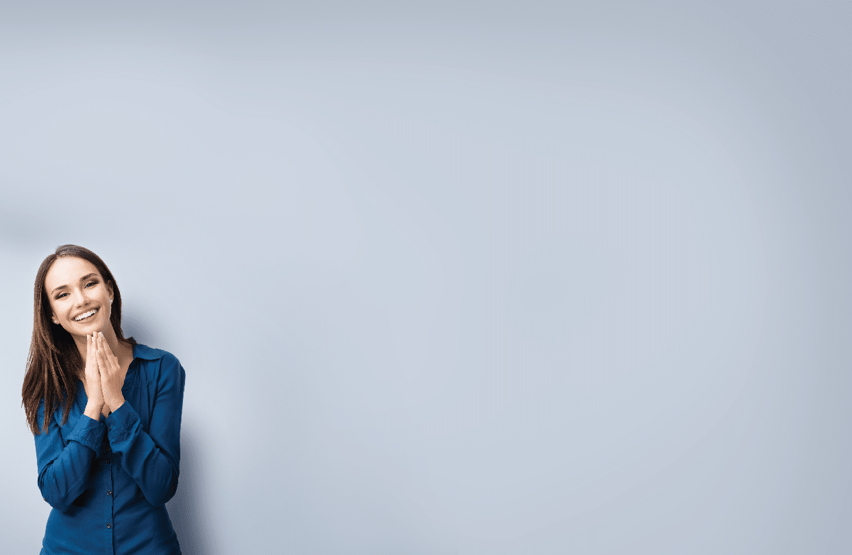 Portrait of happy gesturing smiling young woman in casual smart blue clothing, on grey, with copyspace area for text or slogan