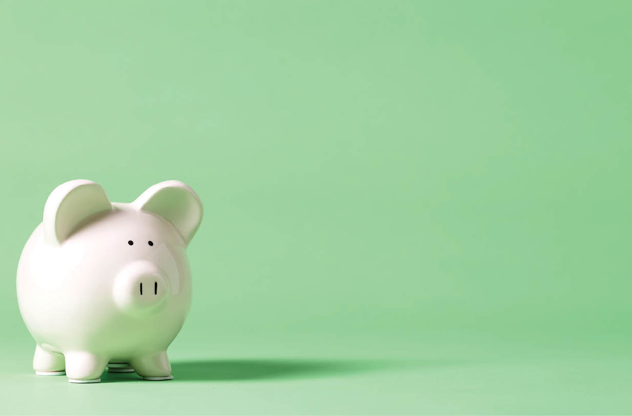 White piggy bank with glasses on a muted green background