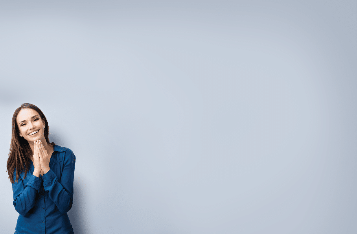 Portrait of happy gesturing smiling young woman in casual smart blue clothing, on grey, with copyspace area for text or slogan